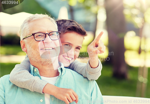 Image of grandfather and boy pointing finger at summer park