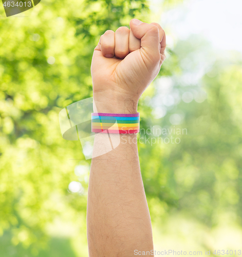 Image of hand with gay pride rainbow wristband shows fist