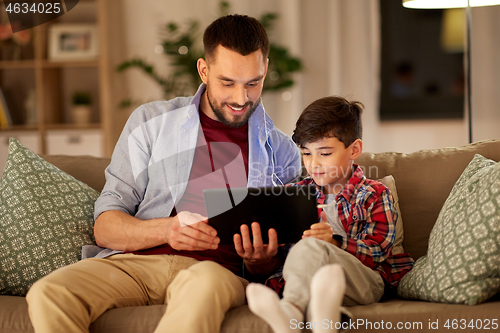 Image of father and son listening to music on tablet pc