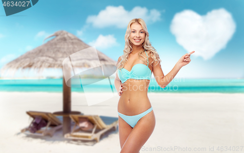 Image of happy smiling young woman in bikini on beach