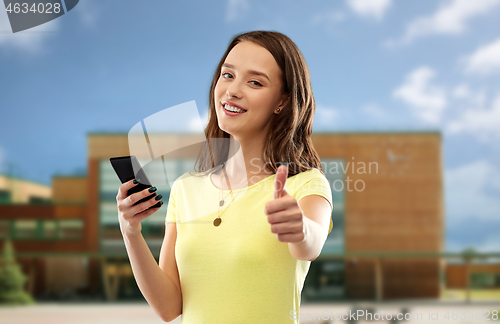 Image of teenage girl with smartphone showing thumbs up