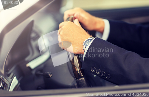 Image of senior businessman hands driving car