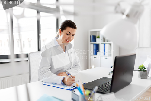 Image of doctor with laptop and medical report at hospital