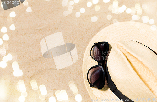 Image of straw hat and sunglasses on beach sand