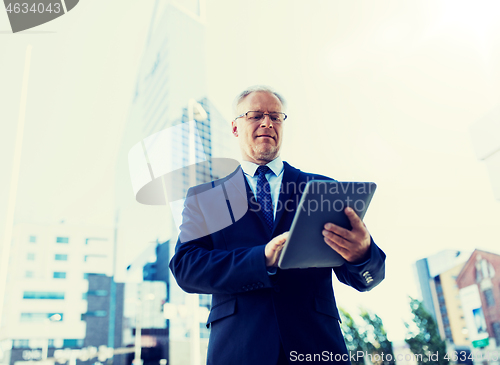 Image of senior businessman with tablet pc on city street