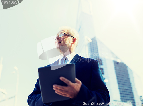 Image of senior businessman with tablet pc on city street