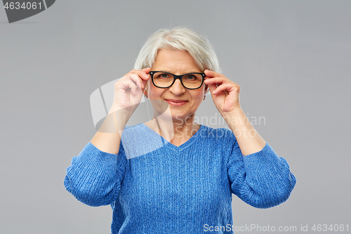 Image of portrait of senior woman in glasses over grey