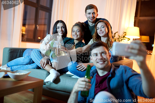 Image of happy friends taking selfie by smartphone at home