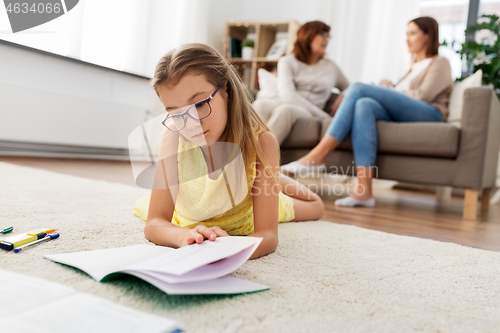 Image of student girl with notebook lying on floor at home