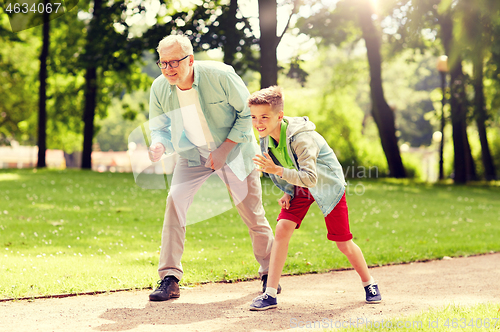 Image of grandfather and grandson racing at summer park