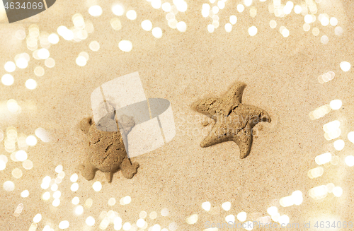 Image of sand shapes of turtle and starfish on summer beach