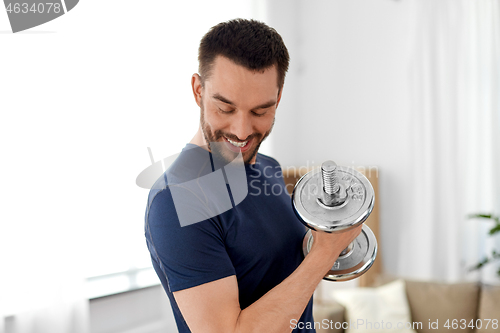 Image of man exercising with dumbbell at home