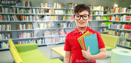 Image of schoolboy in glasses with books at library