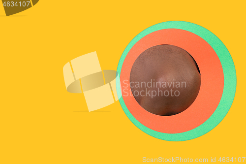 Image of Body of african-american man peeking throught circle in yellow background