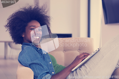 Image of African American women at home in the chair using a laptop