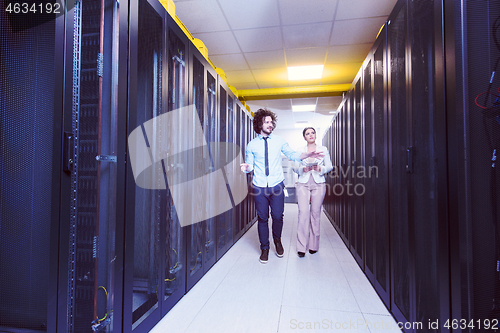 Image of engineer showing working data center server room to female chief