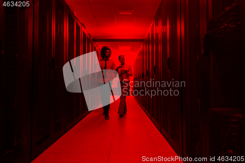 Image of engineer showing working data center server room to female chief