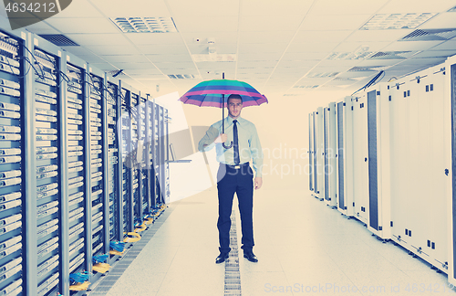 Image of businessman hold umbrella in server room