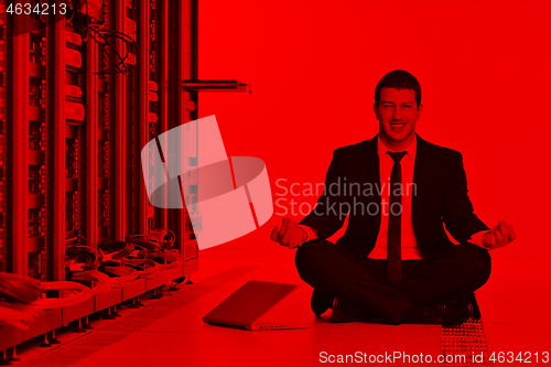 Image of business man practice yoga at network server room