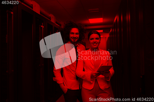 Image of engineer showing working data center server room to female chief