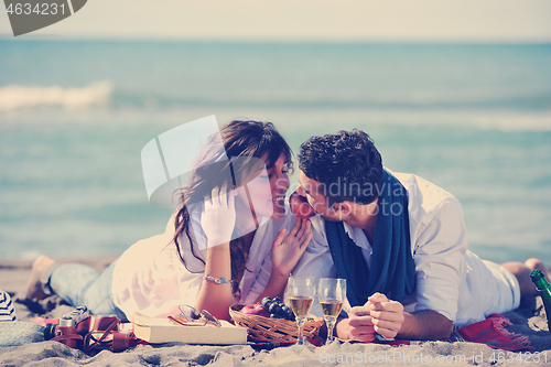 Image of young couple enjoying  picnic on the beach