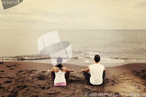 Image of couple yoga beach