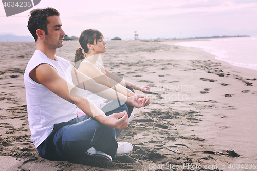 Image of couple yoga beach