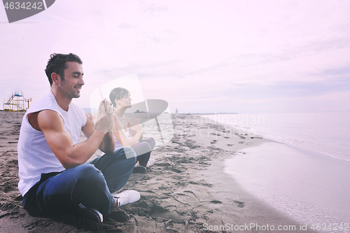 Image of couple yoga beach