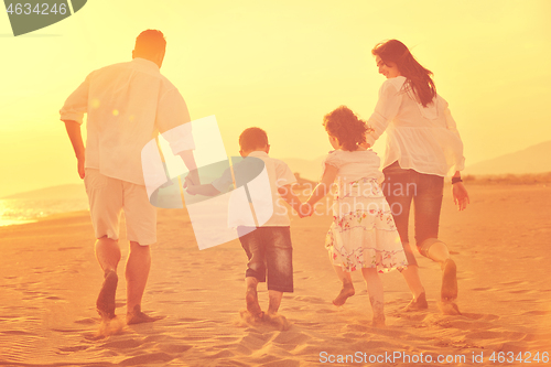 Image of happy young family have fun on beach at sunset