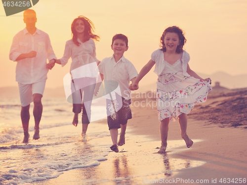 Image of happy young family have fun on beach at sunset