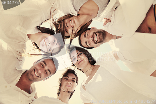 Image of Group of happy young people in circle at beach