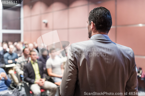 Image of Public speaker giving talk at business event.