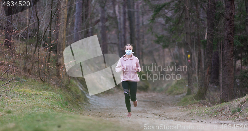 Image of Corona virus, or Covid-19, is spreading all over the world. Portrait of caucasian sporty woman wearing a medical protection face mask while running in nature.