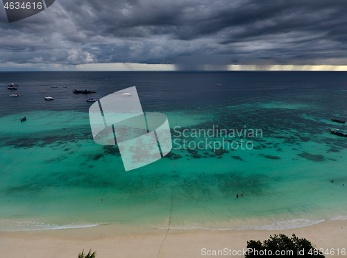 Image of boats at beach and storm clouds