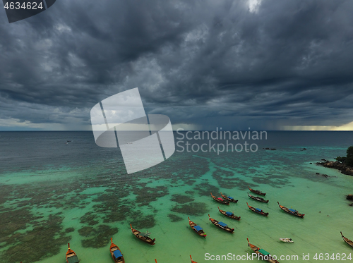 Image of Long tail boats at beach and storm clouds