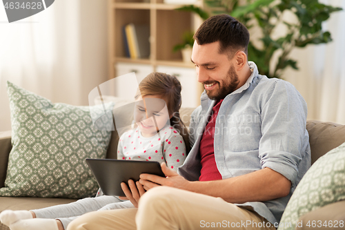 Image of father and daughter with tablet computer at home