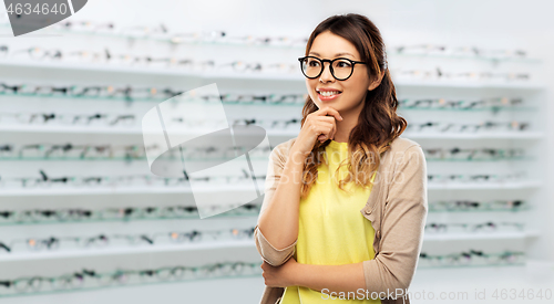 Image of happy asian woman in glasses over optics store