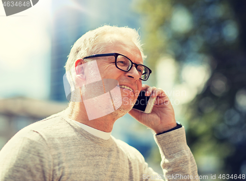 Image of happy senior man calling on smartphone in city