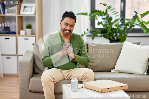 Image of indian man with takeaway pizza box at home