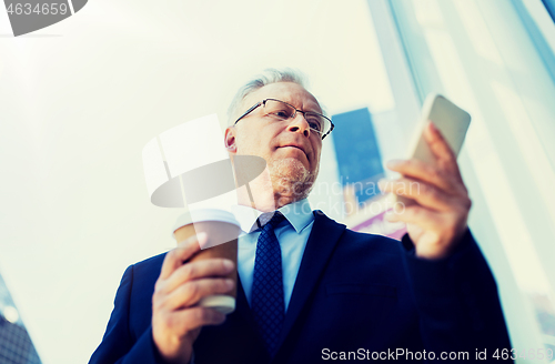 Image of businessman with smartphone and coffee in city