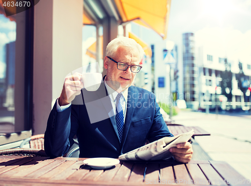 Image of senior businessman with newspaper drinking coffee