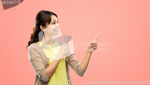 Image of happy asian woman pointing fingers up