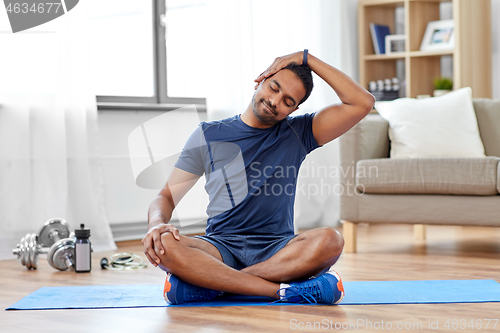 Image of man training and stretching body at home