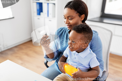 Image of mother with baby son holding medicine at clinic