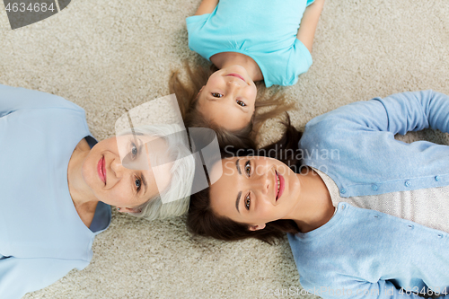 Image of mother, daughter and grandmother lying on floor
