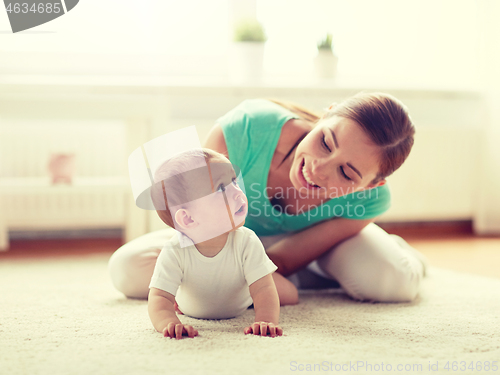 Image of happy mother playing with baby at home