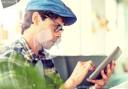 Image of man with tablet pc sitting at cafe table