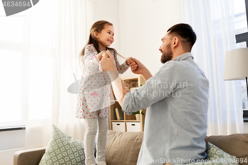 Image of father and daughter jumping and having fun at home