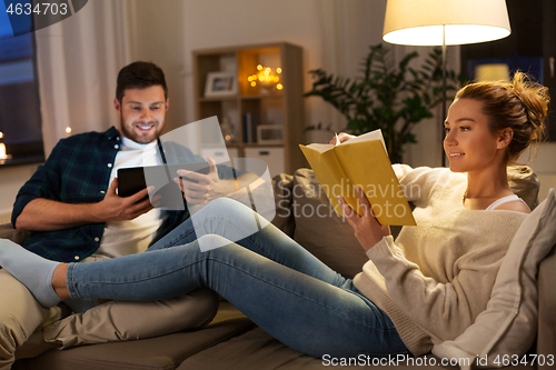 Image of couple with tablet computer and book at home