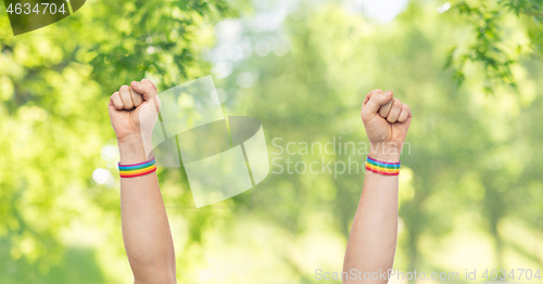 Image of hands with gay pride rainbow wristbands shows fist